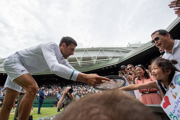 (210712) -- LONDON, July 12, 2021 -- Novak Djokovic of Serbia (1st L) gives a racquet to a young fan in the crowd after winning the men s final match between Novak Djokovic of Serbia and Matteo Berrettini of Italy at Wimbledon tennis Championship in London, Britain, on July 11, 2021. (Photo by Xinhua) (SP)BRITAIN-LONDON-TENNIS-WIMBLEDON-MEN S FINAL TimxIreland 