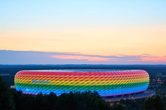 People on the Fröttmaninger Müllberg on the occasion of Christopher Street Day in Munich, the Allianz Arena is illuminated in rainbow colors, which symbolize the colors of the LBGTQ movement in Munich. Bavaria, Germany, July 10, 2021. LGBTQ stands for lesbian, gay, bisexual, transgender, and questioning (or queer).