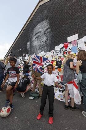 Großbritannien, Black History Month im Oktober - Sport A young boy waves a Union Flag and England Flag as another plays football as people place messages of support at a mural for England footballer Marcus Rashford on July 13th 2021 in Manchester, England after he received racist abuse after missing a penalty during England s Euro 2020 final against Italy. Where: Manchester, Greater Manchester, United Kingdom When: 13 Jul 2021 Credit: Daniel Chesterton phcimages.com Cover Images **NOT AVAILABLE FOR PUBLICATION IN UK NEWSPAPERS** Copyright: xDanielxChesterton phcimages.com CoverxImagesx 0125446820st EDITORIAL USE ONLY. RESTRICTED TO NEWSPAPERS BASED IN THE UK