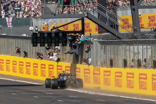 18th July 2021; Silverstone Circuit, Silverstone, Northamptonshire, England; Formula One British Grand Prix, Race Day; Mercedes AMG Petronas F1 Team driver Lewis Hamilton is congratulated by his team on the pit wall as he takes the chequred flag  ActionPlus12307253 TimxWilliams