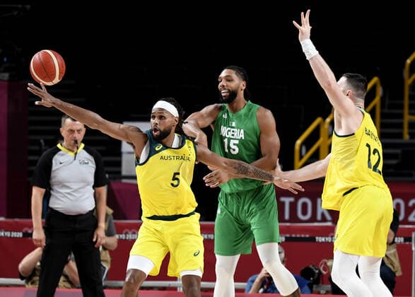 Australia s Patty Mills (5) and Aron Baynes (12) look to steal the ball from Nigeria s Jahlil Okafor (15) during Men s Basketball game at the Tokyo 2020 Olympics, Sunday, July 25, 2021, in Tokyo, Japan. Seating remains empty as spectators are banned from attendance.  OLY2021072581133 MIKExTHEILER