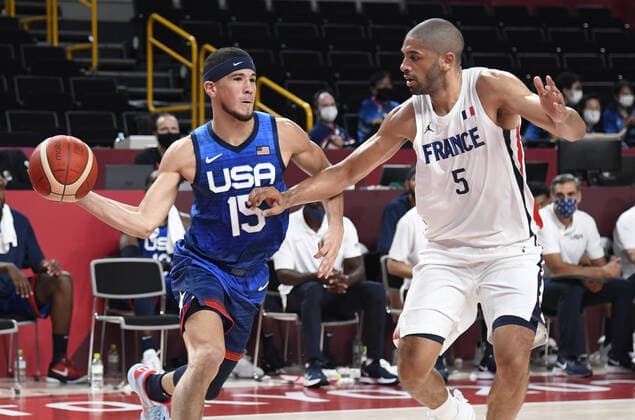 Tokio 2020 im Jahr 2021, Basketball, Herren, Frankreich - USA The United States Devin Booker (L) looks to pass the ball as he defended by France s Nicolas Batum during a Men s Basketball game at the Tokyo 2020 Olympics, Sunday, July 25, 2021, in Tokyo, Japan.  OLY20210725898 MIKExTHEILER