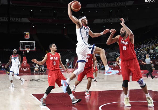 United States Devin Booker (L) drives to the basket as Iran s Hamed Haddadi defends during a Men s Basketball game at the Tokyo 2020 Olympics, Wednesday, July 28, 2021, in Tokyo, Japan. The USA won easily, 120-66.  OLY20210728802 MIKExTHEILER