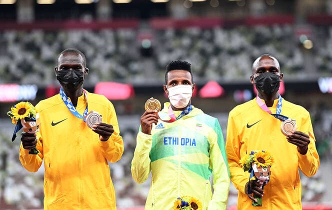 (210731) -- TOKYO, July 31, 2021 -- Gold medalist Selemon Barega (C) of Ethiopia, silver medalist Joshua Cheptegei (L) of Uganda and bronze medalist Jacob Kiplimo of Uganda react on the awarding ceremony of the men s 10000m at the Tokyo 2020 Olympic Games, Olympische Spiele, Olympia, OS in Tokyo, Japan, July 31, 2021. ) (TOKYO2020)JAPAN-TOKYO-OLY-ATHLETICS-MEN S 10000M-AWARDING CEREMONY LixYibo 
