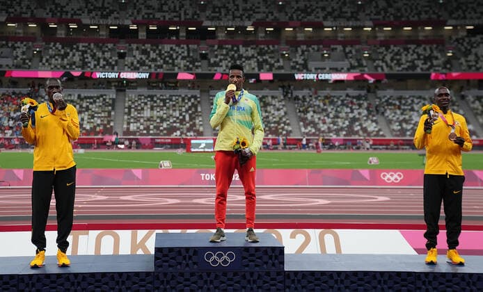 (210731) -- TOKYO, July 31, 2021 -- Gold medalist Selemon Barega (C) of Ethiopia, silver medalist Joshua Cheptegei (L) of Uganda and bronze medalist Jacob Kiplimo of Uganda react on the awarding ceremony of the men s 10000m at the Tokyo 2020 Olympic Games, Olympische Spiele, Olympia, OS in Tokyo, Japan, July 31, 2021. ) (TOKYO2020)JAPAN-TOKYO-OLY-ATHLETICS-MEN S 10000M-AWARDING CEREMONY LixYibo 