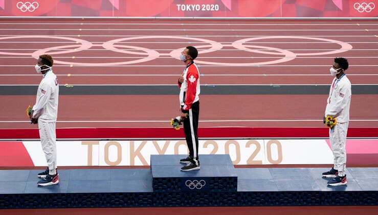 August 5, 2021, Tokyo, Japan: CanadaÃ¢â‚¬â ¢s Andre De Grasse, from Markham, Ont. stands on the podium with Kenny Bednarek (left) and Noah Lyles, from the United States, during the playing of the national anthem and receives the gold medal for the 200m race during a ceremony at the 2020 Tokyo Olympics, Thursday, August 5, 2021 in Tokyo, Japan. Canada News - August 5, 2021  - ZUMAc35_ 20210805_zaf_c35_011 Copyright: xAdrianxWyldx