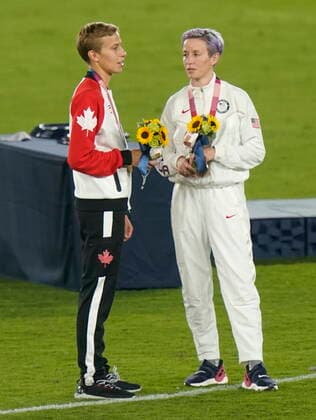 August 7, 2021, Yokohama, Japan: Canadian midfielder Quinn (left) talks with Megan Rapinoe of the USA at the medal ceremony after Canada s win over Sweden in the women s soccer gold medal game at the Tokyo Olympics in Yokohama, Japan on Friday, August 6, 2021. Canada News - August 7, 2021  - ZUMAc35_ 20210807_zaf_c35_014 Copyright: xAdrianxWyldx