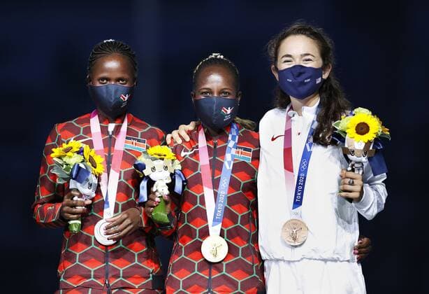 Tokyo Olympics: Athletics Tokyo Olympic women s marathon gold medalist Peres Jepchirchir (C) of Kenya poses for a photo at the victory ceremony held during the closing ceremony of the games at the National Stadium in Tokyo on Aug. 8, 2021, alongside compatriot Brigid Kosgei (L) and Molly Seidel of the United States, who took silver and bronze, respectively. They were wearing face masks for protection against the coronavirus.  A14AA0000757504P