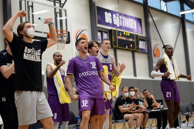 BG Göttingen Medipolis SC Jena 23 08 2021, Basketball Bundesliga, 2021 2022 season, preparation, BG Göttingen Medipolis SC Jena Göttingens Marios Giottis l r , Joris Herbst, Philipp Hartwich and James Dickey cheer on the sidelines Göttingen Lower Saxony Germany.