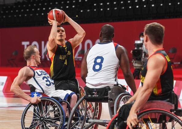 6633137 26.08.2021 Germany s Phillip Schorp, second left, shoots the ball during the men s wheelchair basketball Group B match between the United States and Germany at the Tokyo 2020 Paralympic Games at Ariake Arena in Tokyo, Japan. John Boie, of the United States, is at left. Ilya Pitalev Sputnik Japan Paralympics 2020 Wheelchair Basketball Men USA - Germany  1e0c46bc7989e785