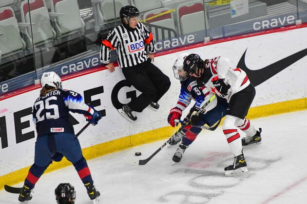 August 26, 2021, Calgary, AB, Canada: An official hops in the air as Canada s ASHTON BELL (right) and JINCY DUNNE (centre right) from The United States fight over the puck during the Canada vs United States preliminary round game at the 2021 IIHF Women s World Championship, WM, Weltmeisterschaft in Calgary, AB, Canada on 26 August, 2021. Canada defeated the United States 5-1 to take first place in the preliminary round. The last time Canada beat the United States at the World Championship was in 2013. Calgary Canada - ZUMAj113 0131781035st Copyright: xGavinxJohnx