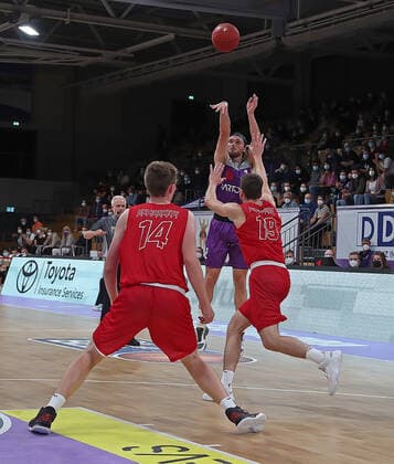 GSD zje123 Easy Credit Basketball BBL BG Göttingen Paderborn Göttingens Jake Toolson on the ball against Paderborns Johannes Konradt right and Benedict Dernbach.