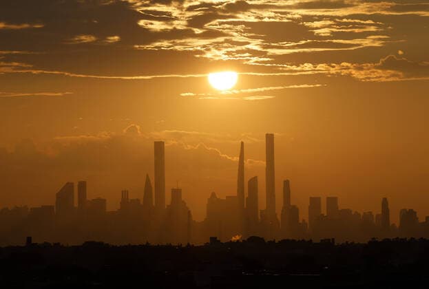 The sun sets behind the Manhattan skyline from Arthur Ashe Stadium in the first round of the 2021 US Open Tennis Championships at the USTA Billie Jean King National Tennis Center on Monday, August 30, 2021 in New York City.  NYP20210830151 JOHNxANGELILLO