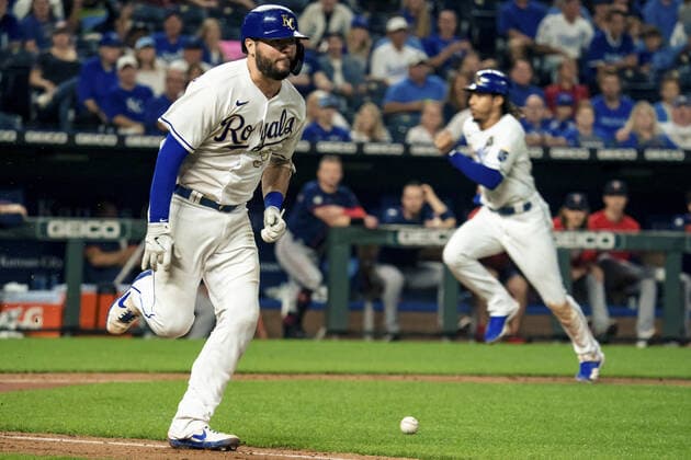Kansas City Royals catcher Cam Gallagher (36) lays down a bunt against the Minnesota Twins and scores shortstop Adalberto Mondesi (27) in the sixth inning at Kaufman Stadium in Kansas City, Missouri on Friday, October 1, 2021.  KCP20211001121 KYLExRIVAS