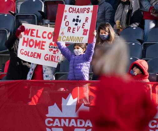 October 23, 2021, Ottawa, on, Canada: A Canadian player runs past during warm up as two Canadian fans hold up signs before a friendly match between Canada and New Zealand, in Ottawa, Saturday, Oct. 23, 2021. Canada News - October 23, 2021  - ZUMAc35_ 20211023_zaf_c35_013 Copyright: xAdrianxWyldx