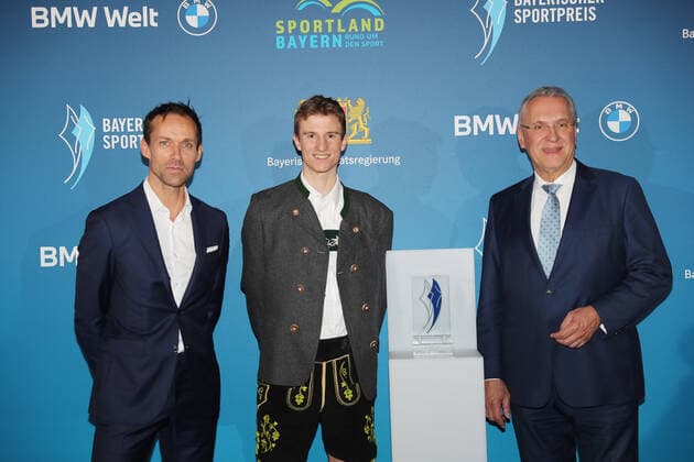 Bavarias Minister of the Interior Joachim Herrmann honours Karl Geiger with the Bavarian Sports Award 2021 as ambassador of Bavarian sports Sven Hannawald, Karl Geiger and Bavarian Minister of the Interior Joachim Herrmann Munich Bavaria Germany BMW World