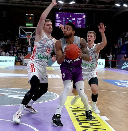 GSD zje123 easy Credit Basketball BBL Season 2020 21 BG Göttingen FC Bayern Munich Göttingens Jeff Roberson on the ball against Munichs Andreas Obst left and Ognjen Jaramaz.