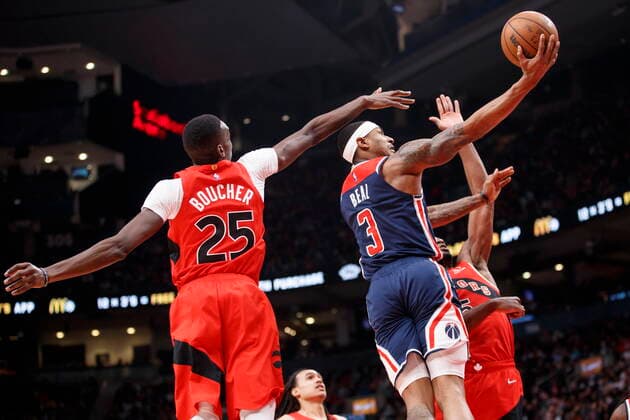 December 5, 2021, Toronto, ON, CANADA: Washington Wizards guard Bradley Beal (3) goes to the hoop between Toronto Raptors Chris Boucher (25) and teammate Precious Achiuwa (5) during the second half NBA, Basketball Herren, USA action in Toronto, Sunday, Dec. 5, 2021. Raptors Wizards NBA Action  - ZUMAc35_ 20211205_zaf_c35_214 Copyright: xColexBurstonx