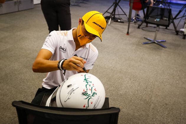 NORRIS Lando (gbr), McLaren MCL35M, portrait signing helmet and book for TODT Jean (fra), FIA President during the Formula 1 Etihad Airways Abu Dhabi Grand Prix 2021, 22th round of the 2021 FIA Formula One World Championship, WM, Weltmeisterschaft from December 10 to 12, 2021 on the Yas Marina Circuit, in Yas Island, Abu Dhabi - F1 - ABU DHABI GRAND PRIX 2021 DPPI Panoramic  00121045__V2_8233.JPG