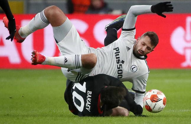WARSAW, POLAND - DECEMBER 9, 2021: Legia s Mateusz Wieteska (top) and Spartak s Zelimkhan Bakayev in action in the 2021 22 UEFA Europa League Group C Round 6 match between Spartak Moscow and Legia Warsaw at the Marshall Jozef Pilsudski s Municipal Stadium of Legia Warsaw. Alexander Demianchuk TASS  TS11B4BE