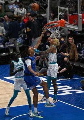 DALLAS, TX - DECEMBER 13: Dallas Mavericks center Moses Brown tries to dunk while being defended by Charlotte Hornets guard Kelly Oubre Jr. (right) and J. T. Thor (21)during game featuring the Charlotte Hornets and the Dallas Mavericks on December 13, 2021 at the American Airlines Center in Dallas, TX. (Photo by John Rivera Icon Sportswire) NBA, Basketball Herren, USA DEC 13 Hornets at Mavericks Icon426211213016