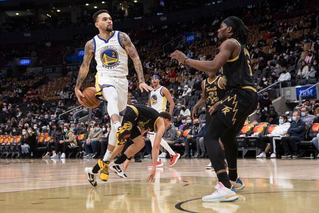 December 18, 2021, Toronto, ON, Canada: Golden State Warriors Chris Chiozza makes a reverse pass in front of Toronto Raptors Precious Achiuwa during second half NBA, Basketball Herren, USA basketball action in Toronto on Saturday, December 18, 2021. Canada News - December 18, 2021  - ZUMAc35_ 20211218_zaf_c35_118 Copyright: xChrisxYoungx