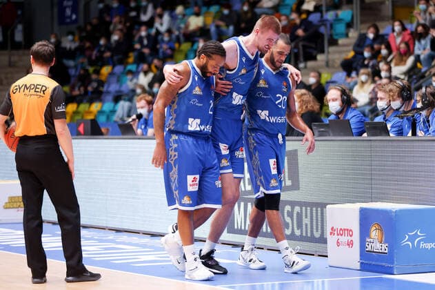 Fraport Skyliners Syntainics MBC, easyCredit BBL Quantez Robertson Fraport Skyliners, 23 and Rasheed Moore Fraport Skyliners, 20 lead the injured Matt Haarms Fraport Skyliners, 3 off the court easyCredit BBL basketball match between Fraport Skyliners and Mitteldeutsche Basketball Club at Ballsporthalle in Frankfurt am Main , Frankfurt am Main Hesse Germany Ballsporthalle on December 19, 2021.