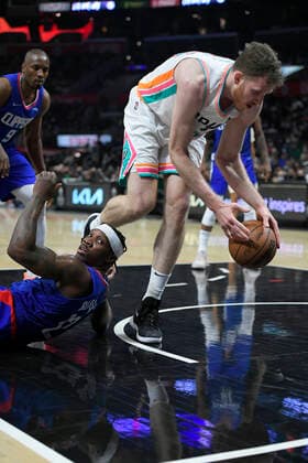 LOS ANGELES, CA - DECEMBER 20: San Antonio Spurs center Jakob Poeltl (25) takes a loose ball away from LA Clippers guard Eric Bledsoe (12) in the second half of an NBA, Basketball Herren, USA game on December 20, 2021, at Staples Center in Los Angeles, CA. (Photo by John McCoy Icon Sportswire) NBA: DEC 20 Spurs at Clippers Icon2112204804