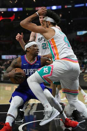 LOS ANGELES, CA - DECEMBER 20: LA Clippers guard Eric Bledsoe (12) slips while guarded by San Antonio Spurs guard Derrick White (4) in the second half of an NBA, Basketball Herren, USA game on December 20, 2021, at Staples Center in Los Angeles, CA. (Photo by John McCoy Icon Sportswire) NBA: DEC 20 Spurs at Clippers Icon2112204493