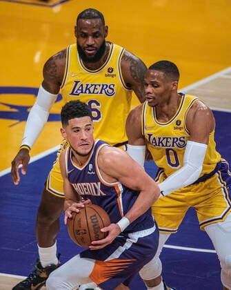 December 21, 2021, Los Angeles, California, USA: Devin Booker 1 of the Phoenix Suns is defended by LeBron James 6 and Russell Westbrook 0 of the Los Angeles Lakers during their NBA, Basketball Herren, USA game on Tuesday December 21, 2021 at the Staples Center in Los Angeles, California. Lakers lose to Suns, 90-108. PI Los Angeles USA - ZUMAp124 20211221_zaa_p124_006 Copyright: xJAVIERxROJASx