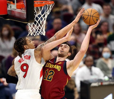 Cleveland Cavaliers Luke Kornet (12) is fouled by Toronto Raptors D.J. Wilson (9) at Rocket Mortgage FieldHouse in Cleveland, Ohio on Sunday, December 26, 2021.  CLE20211226101 AARONxJOSEFCZYK