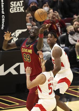 Cleveland Cavaliers Tacko Fall (99) grabs a rebound over Toronto Raptors Tremont Waters (51) at Rocket Mortgage FieldHouse in Cleveland, Ohio on Sunday, December 26, 2021.  CLE20211226124 AARONxJOSEFCZYK