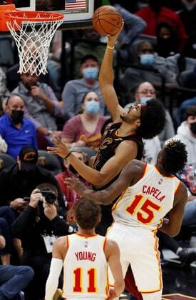 Jarrett Allen (C) of the Cleveland Cavaliers goes to the basket against Clint Capela (R) of the Atlanta Hawks as Hawks guard Trae Young (L) looks on during the second half of the NBA, Basketball Herren, USA game between the Cleveland Cavaliers and the Atlanta Hawks at Rocket Mortgage Fieldhouse in Cleveland, Ohio, USA, 31 December 2021. Atlanta Hawks at Cleveland Cavaliers !ACHTUNG: NUR REDAKTIONELLE NUTZUNG!  Copyright: xDAVIDxMAXWELLx AME6992 20220101-60af9a97b6f5972fdbfb7b9c207e39d3875a272c