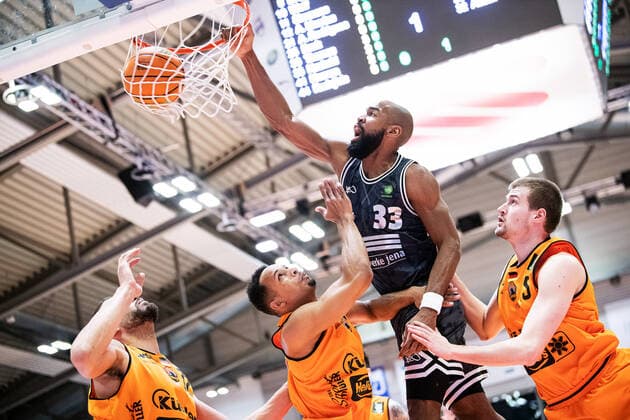 BARMER 2 Basketball Bundesliga Season 2021 2022 Matchday 18 on 11 01 22 Medipolis SC Jena vs wiha Panthers Schwenningen center Brandon Thomas Jena dots the ball into the basket against three schwenningen opponents Sparkassen Arena