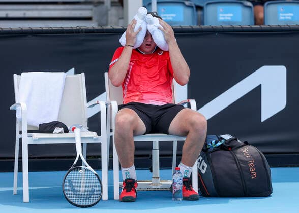 Dominic Stricker SUI uses an ice pack because of the heat,, Qualifying Round, Australian Open 2022 Copyright: xJuergenxHasenkopfx