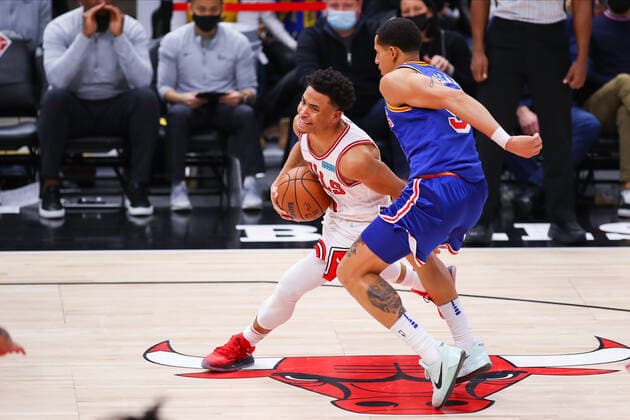 CHICAGO, IL - JANUARY 14: Chicago Bulls Guard Devon Dotson (3) drives to the basket while being defended by Golden State Warriors Center Kevon Looney (5) during a NBA, Basketball Herren, USA game between the Golden State Warriors and the Chicago Bulls on January 14, 2022 at the United Center in Chicago, IL. (Photo by Melissa Tamez Icon Sportswire) NBA: JAN 14 Warriors at Bulls Icon22011448