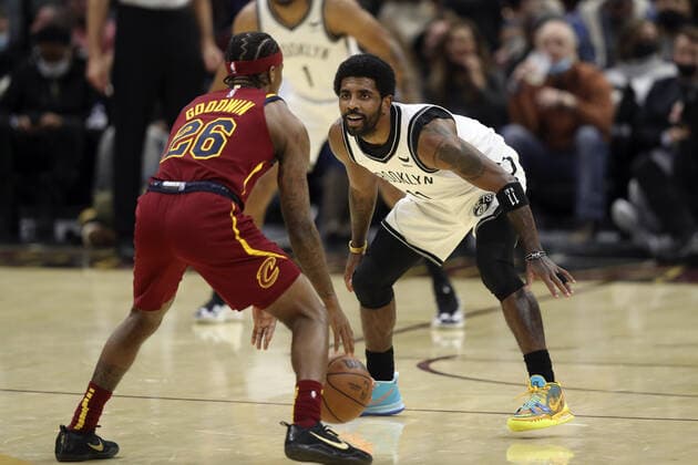 Sport Bilder des Tages Brooklyn Nets Kyrie Irving (11) defends Cleveland Cavaliers Brandon Goodwin (26) at Rocket Mortgage Field House in Cleveland, Ohio on Monday, January 17, 2022.  CLE20220117102 AARONxJOSEFCZYK