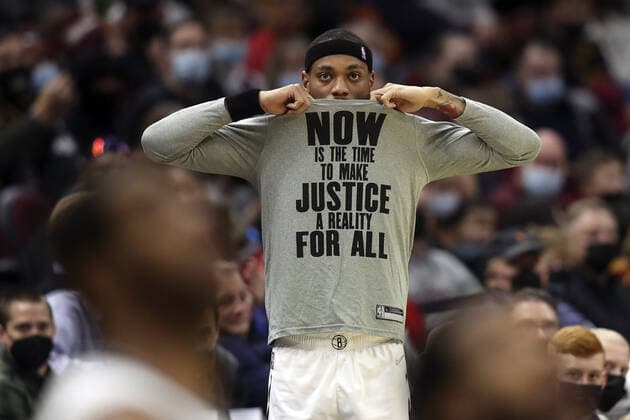 Brooklyn Nets Bruce Brown (1) removes his MLK Day shirt before entering the game against the Cleveland Cavaliers at Rocket Mortgage Field House in Cleveland, Ohio on Monday, January 17, 2022.  CLE20220117103 AARONxJOSEFCZYK