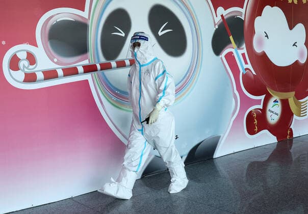 BEIJING, CHINA - JANUARY 28, 2022: An employee is seen by a poster depicting Bing Dwen Dwen (L), the mascot of the 2022 Winter Olympics, and Shuey Rhon Rhon, the mascot of the 2022 Winter Paralympics, at Beijing Capital International Airport. The 24th Winter Olympic Games, Olympische Spiele, Olympia, OS are scheduled to take place in Beijing on February 4-20, 2022. Valery Sharifulin TASS  0149073047st