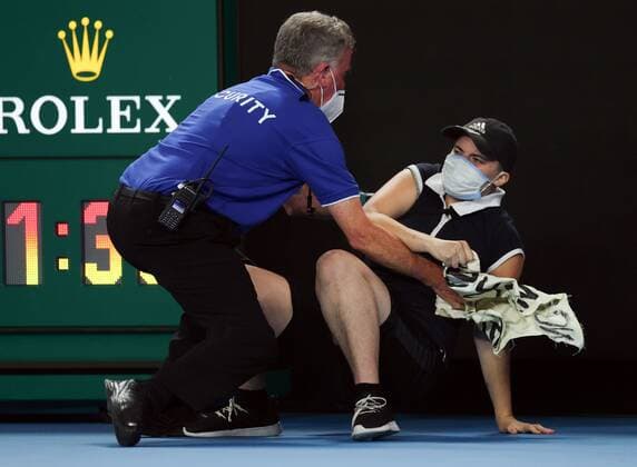 Mandatory Credit: Photo by Ella Ling Shutterstock (12778014bd) A protester is tackled by security and police during the Men s Singles final Australian Open, Day Fourteen, Tennis, Melbourne Park, Melbourne, Australia - 30 Jan 2022 Australian Open, Day Fourteen, Tennis, Melbourne Park, Melbourne, Australia - 30 Jan 2022 Copyright: xEllaxLing Shutterstockx 12778014bd