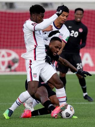 January 30, 2022, Hamilton, ON, CANADA: Canada s Cyle Larin (17) falls under a challenge from United States Yunus Musah (6) and teammate Miles Robinson (12) during first half World Cup qualifying soccer action in Hamilton, Ont., Sunday, Jan. 30, 2022. Canada News - January 30, 2022  - ZUMAc35_ 20220130_zaf_c35_050 Copyright: xFrankxGunnx