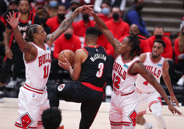 CHICAGO, IL - JANUARY 30: Portland Trail Blazers guard CJ McCollum (3) goes between Chicago Bulls forward DeMar DeRozan (11) and Chicago Bulls guard Ayo Dosunmu (12) during a NBA, Basketball Herren, USA game between the Portland Trail Blazers and the Chicago Bulls on January 30, 2022 at the United Center in Chicago, IL. (Photo by Melissa Tamez Icon Sportswire) NBA: JAN 30 Trail Blazers at Bulls Icon22013037