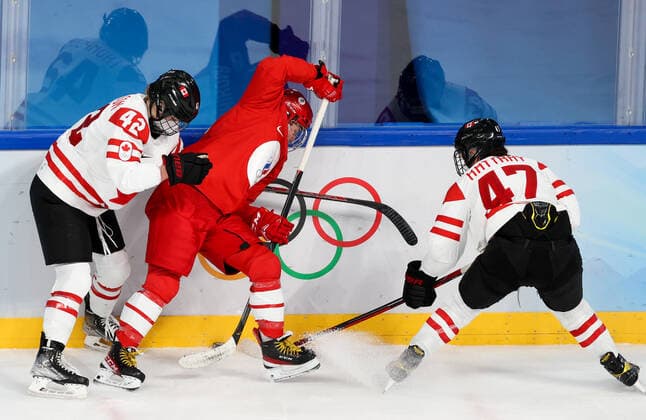 BEIJING, CHINA - FEBRUARY 7, 2022: Claire Thompson of Canada, Polina Luchnikova of the ROC Team and Jamie Lee RattRay (L-R) of Canada fight for the puck in their women s Group A Ice hockey, Eishockey match at the 2022 Winter Olympic Games, Olympische Spiele, Olympia, OS at the Wukesong Sports Centre. Anton Novoderezhkin TASS  TS121B67