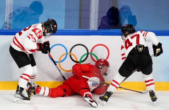 BEIJING, CHINA - FEBRUARY 7, 2022: Claire Thompson of Canada, Polina Luchnikova of the ROC Team and Jamie Lee RattRay (L-R) of Canada fight for the puck in their women s Group A Ice hockey, Eishockey match at the 2022 Winter Olympic Games, Olympische Spiele, Olympia, OS at the Wukesong Sports Centre. Anton Novoderezhkin TASS  TS121B68