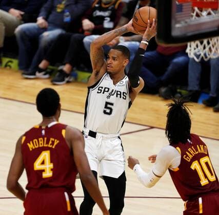 San Antonio Spurs guard Dejounte Murray (C) passes the ball as he is defended by Cleveland Cavaliers forward Evan Mobley (L) and Cleveland Cavaliers center Jarrett Allen (R) during a NBA, Basketball Herren, USA game between the Cleveland Cavaliers and the San Antonio Spurs, at Rocket Mortgage Fieldhouse in Cleveland, Ohio, US, 09 February 2022. San Antonio Spurs at Cleveland Cavaliers !ACHTUNG: NUR REDAKTIONELLE NUTZUNG!  Copyright: xDAVIDxMAXWELLx AME4731 20220210-ee98c2fd3aea7bb974a560c633007a17afa29815
