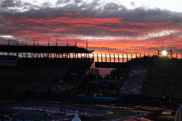 leuchtend roteorange Wolken beim Sonnenuntergang hinter dem Baseballstadion der Rennstrecke Autodromo Hermanos Rodriguez während auf der Rennstrecke noch Vorbereitungen für den nächsten Tag getroffen werden, Formel E FIA Weltmeisterrschaft, Saison 8, Mexiko- City E- Prix, 11.02.2022, MEX