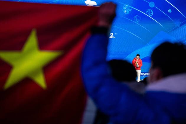 220212 Spectators hold a Chinese flag as Olympic gold medalist Gao Tinguy of China stand on the podium at the medal ceremony for men s speed skating 500 meters during day 8 of the 2022 Winter Olympics on February 12, 2022 in Beijing Photo Mathias Bergeld BILDBYRAN kod MB MB0332 sweden sweden skates speed skating olympic games olympics winter olympics os ol olympic games winter os olympic games peking peking 2022 beijing 2022 beijing 2022 olympic games beijing 2022 winter olympic games peking os beijing ol winter ol 8 bbeng medal ceremony medal ceremony china,  Copyright: MATHIASxBERGELD BB220212MB100