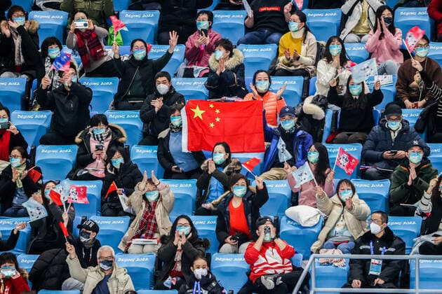 BEIJING, CHINA â€“ FEBRUARY 14, 2022: Spectators wave a Chinese national flag as they watch the free dance event as part of the Figure skating, Eiskunstlauf competition at the Beijing 2022 Winter Olympic Games, Olympische Spiele, Olympia, OS at the Capital Indoor Stadium. Valery Sharifulin TASS  TS122FCB