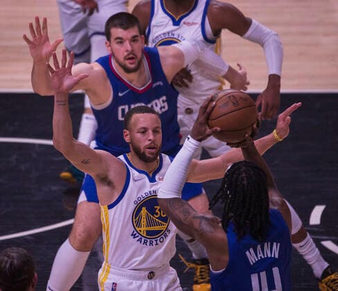 February 14, 2022, Los Angeles, California, USA: Terance Mann 14 of the Los Angeles Clippers passes the ball as Stephen Curry 30 of the Golden State Warriors blocks him during their NBA, Basketball Herren, USA game on Monday February 14, 2022 at Crypto.com Arena in Los Angeles, California. Clippers defeat Warriors, 119-104. ARIANA RUIZ PI Los Angeles USA - ZUMAp124 20220214_zaa_p124_009 Copyright: xArianaxRuizx