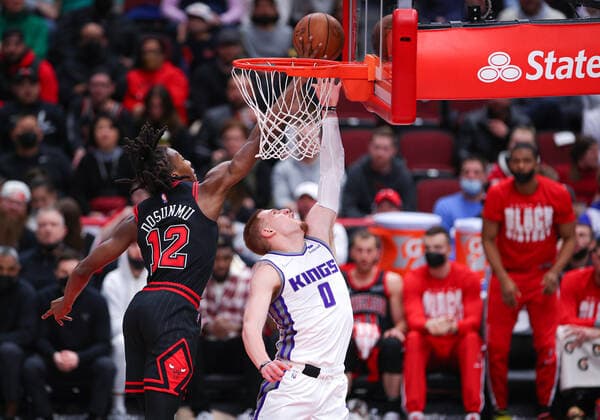 CHICAGO, IL - FEBRUARY 16: Chicago Bulls guard Ayo Dosunmu (12) blocks Sacramento Kings guard Donte DiVincenzo (0) basket during a NBA, Basketball Herren, USA game between the Sacramento Kings and the Chicago Bulls on February 16, 2022 at the United Center in Chicago, IL. (Photo by Melissa Tamez Icon Sportswire) NBA: FEB 16 Kings at Bulls Icon22021623